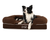 black and white dog on brown bolster dog bed