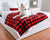 Samoyed resting on winter plaid buffalo red blanket