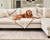 golden retriever resting on white faux fur blanket on white couch