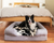 black faux cowhide topper on bolster bed with dog on top in bedroom